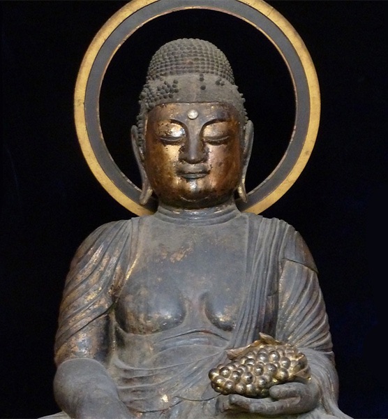 Statua di Buddha che tiene in mano un grappolo d'uva in un tempio giapponese