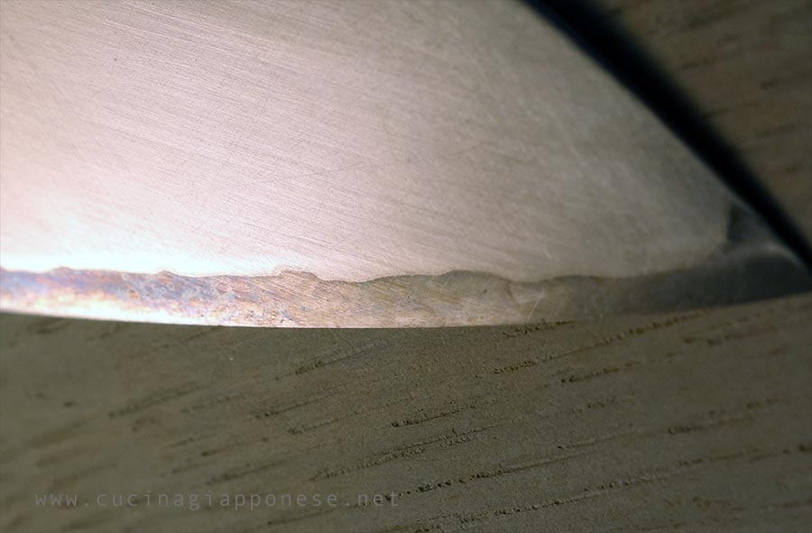 punta di un coltello da cucina giapponese in cui si nota il punto di giuntura di due tipi di acciaio